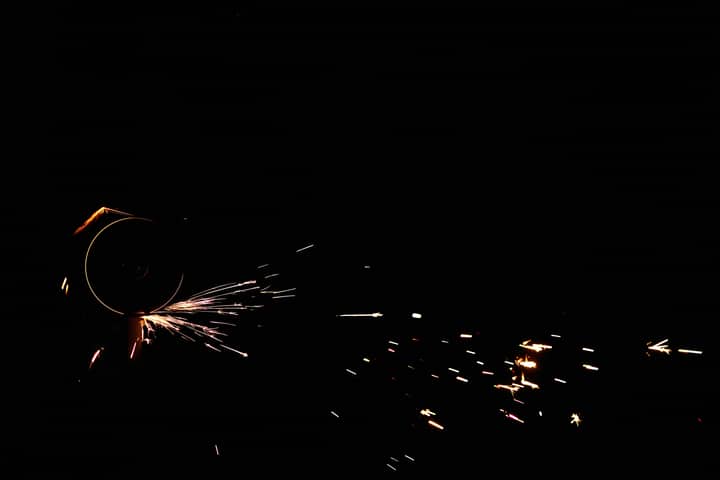 Close-up of an angle grinder creating vibrant sparks against a dark background.