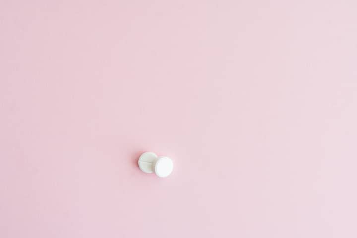 Two white tablets on a soft pink background, showcasing minimalist design.