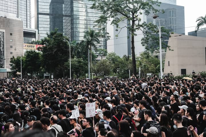Massive crowd gathers during a protest in Hong Kong's urban district, showcasing urban activism.