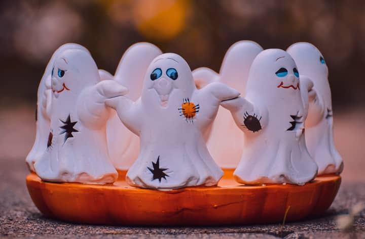 Adorable ceramic ghost figurines in Halloween theme, perfect for festive decoration.