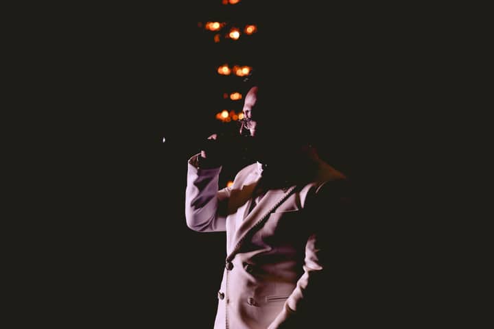 A captivating silhouette of a singer on stage with dramatic lighting and ambiance.