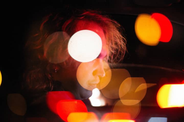 Artistic portrait of a man with colorful bokeh lighting effects at night.