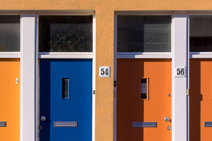 Brightly colored doors with numbers 54 and 56 on a modern building facade.