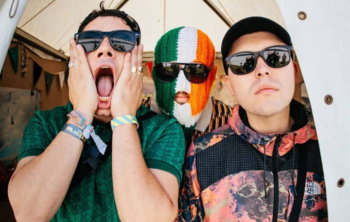 Kneecap pledge to give sales profits to charity as they score highest chart position for Irish language album with ‘Fenian’ landing at Number Two in UK